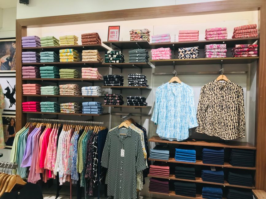 Interiér showroomu, stojany s kostýmami a skúšobné kabínky